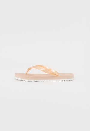 Chinelo em pêssego claro com tiras brilhantes, palmilha texturizada e sola branca com ranhuras. Apresenta o logótipo da marca embutido na tiras.