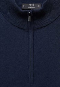 Tmavě modrý svetr z merino vlny s vysokým límcem, vybavený předním zipem a texturovaným pleteným vzorem.