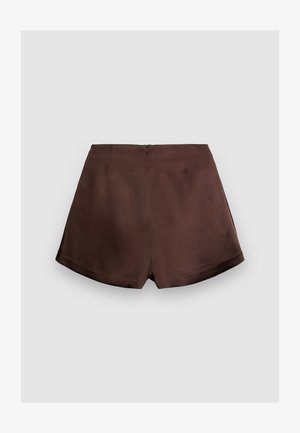 Shorts marroni con una consistenza liscia, caratterizzati da una discreta cerniera posteriore e due tasche posteriori, progettati con una vestibilità su misura e una leggera curvatura all'orlo.