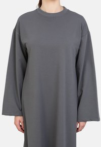 Abito felpa grigio con maniche lunghe, realizzato in tessuto morbido. Presenta un collo rotondo e una vestibilità ampia per il comfort.