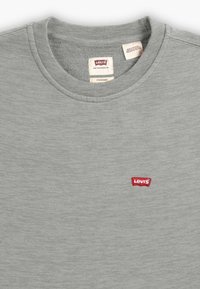 Szary bawełniany sweter z okrągłym dekoltem, z małym czerwonym logo Levi's na piersi. Gładka tekstura, klasyczny krój i ściągacz przy dekolcie.