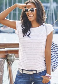 Weiß gestreiftes T-Shirt mit kurzen Ärmeln, blaue Denim-Shorts, geflochtenem weißen Gürtel und einer gestreiften Tasche. Accessoires umfassen weiße Sonnenbrillen und Armbänder.