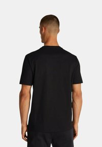T-shirt nera a maniche corte con scollatura rotonda, realizzata in tessuto morbido. Presenta un retro semplice, senza modelli o design visibili.
