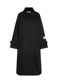 Langer schwarzer Mantel mit weitem Kragen, knöpfbaren Manschetten, Seitentaschen und einem weißen Logo-Patch auf dem rechten Ärmel.