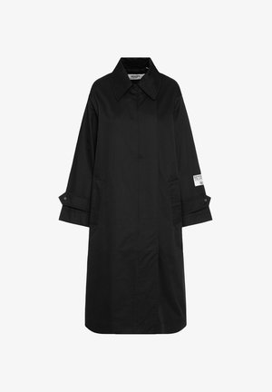 Long black coat with wide collar, buttoned cuffs, side pockets, and a white logo patch on the right sleeve.