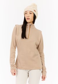 Langsleeve, quarter-zip top in een bruin en roomkleurig geruit patroon met een gladde textuur. Gepaard met een licht gebreide roomkleurige beanie.