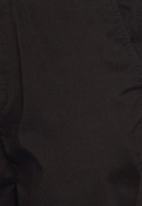 Black fabric with a smooth texture, featuring subtle sheen and soft drape. No visible patterns or hardware details.