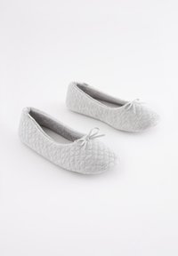 Grau gesteppte Ballerinas aus Stoff mit abgerundetem Zehenbereich und kleinem Schleifendetail vorne; weiche Textur und tiefer Schnitt.