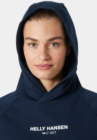 Sudadera azul marino con un gran bolsillo frontal, capucha con cordón y logotipo en texto blanco. Tejido suave con un acabado texturizado.
