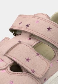 Ροζ παιδικό σανδάλι με δύο ρυθμιζόμενα λουριά διακοσμημένα με μικρά μωβ αστέρια και λευκή υφασμάτινη σόλα.