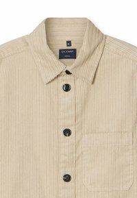 Beige Kordhemd mit Kragen, fünf schwarzen Knöpfen und einer einzelnen Brusttasche. Hat eine vertikale Rippstruktur. Etikett trägt die Aufschrift "OLYMP."
