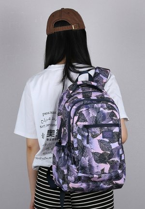 Zaino con un motivo di foglie viola e nere, realizzato in tessuto. Presenta diverse tasche e spalline imbottite.