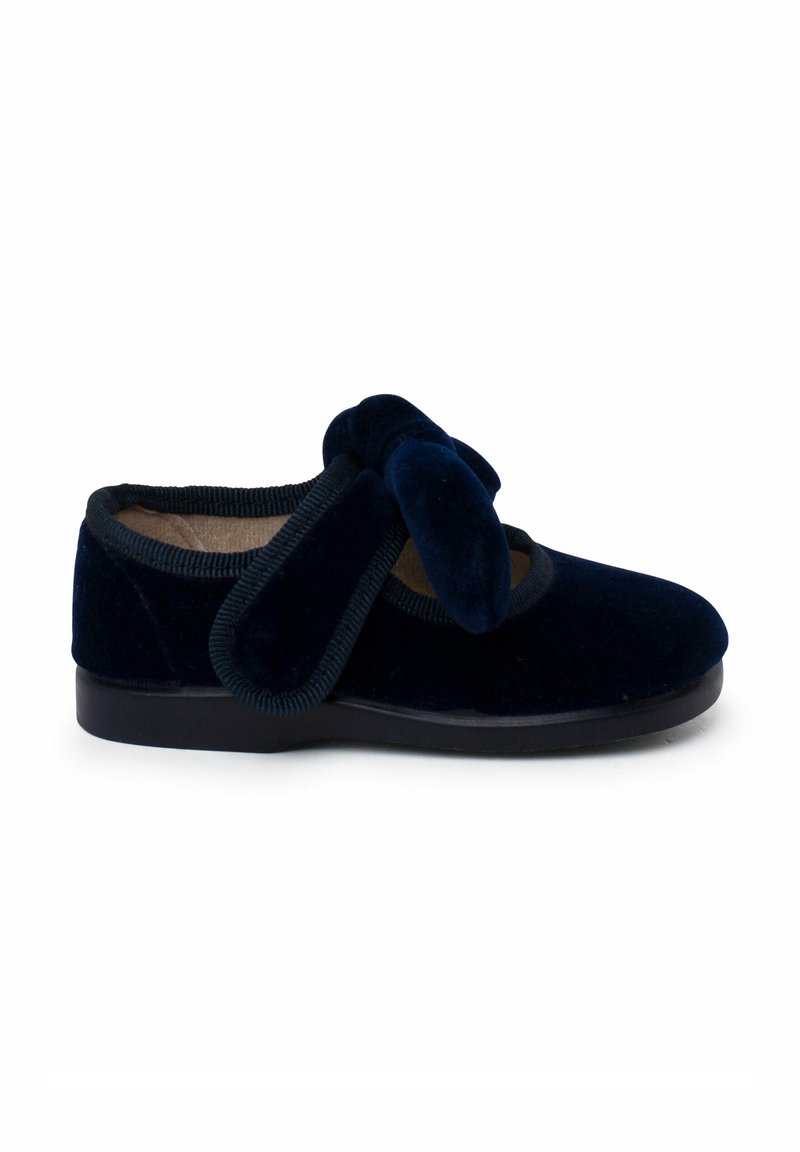 Navyblauwe fluwelen schoen met een ronde neus, voorzien van een grote zachte strikaccent en elastische afwerking rond de opening, aangevuld met een zwarte zool.