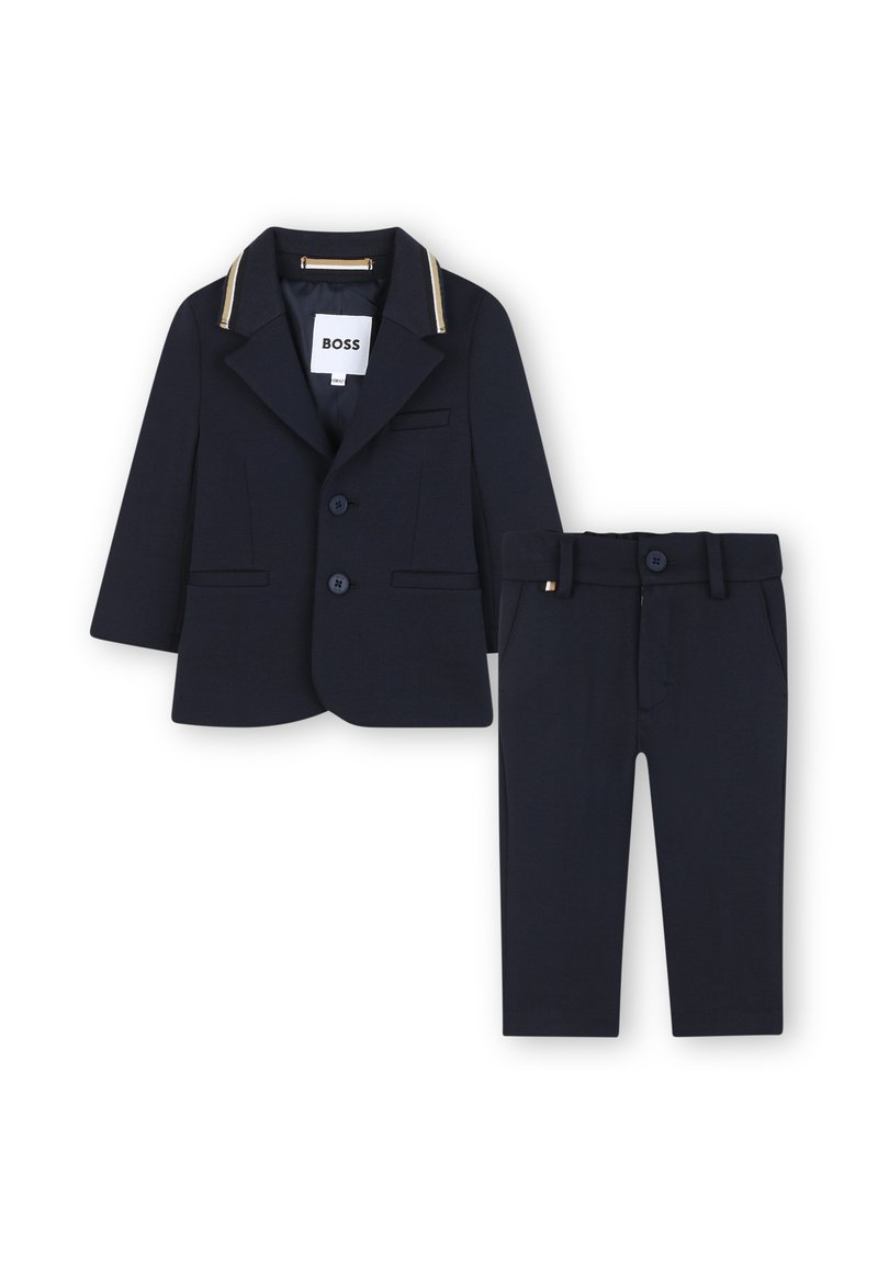 Granatowy zestaw garniturowy z dwuknopfową marynarką z złotymi akcentami oraz dopasowanymi spodniami bez mankietów. Gładki materiał, dopasowany krój, minimalistyczny design.