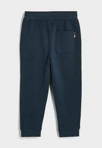 Svetari marinovi s plišastim materialom, z obrobo na pasu, rebrastimi manšetami in enim zadnjim žepom z barvnim poudarkom.