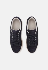 Adidași din suede bleumarin cu un finisaj texturat, talpă din cauciuc bej deschis contrastantă și șase perechi de gauri pentru șireturi asortate pentru o potrivire sigură.