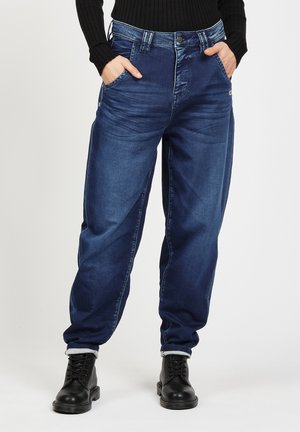 Denim jeans in dark blue with a relaxed fit. Features five pockets, a button fly, and rolled cuffs. The fabric has a smooth, slightly distressed texture.