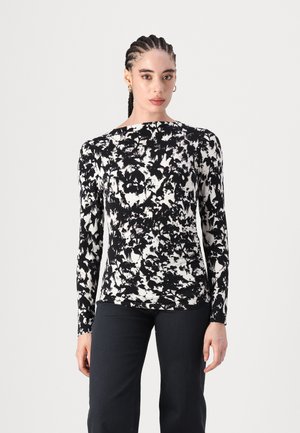 Long-sleeve top in black and white abstract print, featuring a round neckline and fitted silhouette, made from a smooth, stretchy fabric.