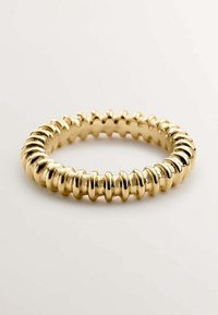 Anillo de oro con una serie de estrías suaves y redondeadas. El diseño cuenta con una textura uniforme y una forma circular, destacando su brillo metálico.