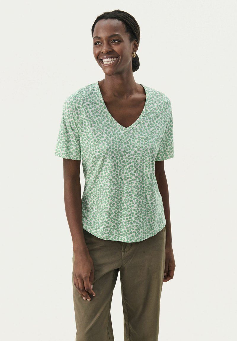 Grön kortärmad V-ringad t-shirt med ett blommönster i mörkgrön och vitt, tillverkad av mjukt tyg, med en avslappnad passform och rundad nederkant.