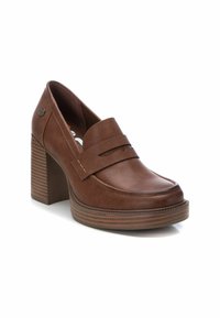 Mocasines de cuero marrón con tacón, con una puntera redondeada, que presentan una correa horizontal en la parte frontal y un tacón de madera apilada texturizado.