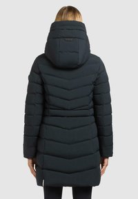 Giacca puffer di colore blu scuro con un design a motivo chevron, cappuccio integrato e chiusura a zip. Presenta polsini elastici e un accento con logo.