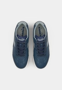 Navy blue sneakers with smooth leather upper and gray accents. Features round toe, lace-up design, cushioned collar, and white rubber sole.