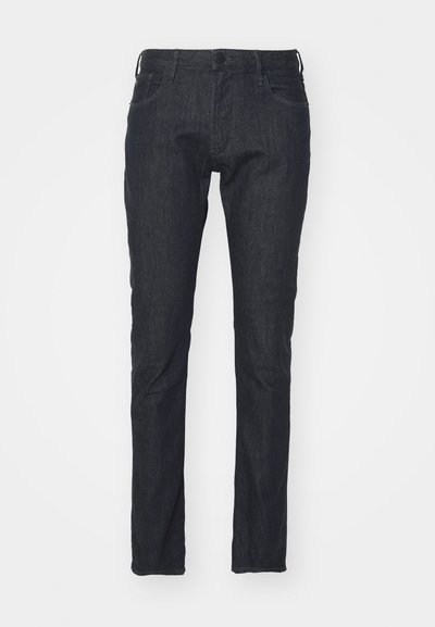Mørkeblå denimjeans med slim passform, fem-lommen design, frontlukking med knapp og subtilt falmet tekstur langs bena.