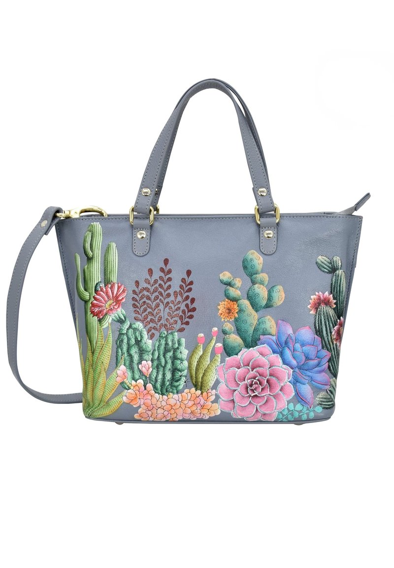 Grijze leren totebag met levendige geborduurde cactussen en vetplanten in roze, groen en blauw. Inclusief dubbele handgrepen aan de bovenkant en een verstelbare schouderriem.