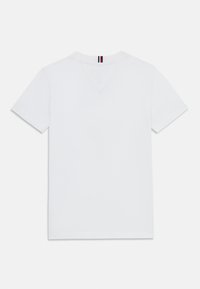 Weißes Baumwoll-T-Shirt mit kurzen Ärmeln, V-Ausschnitt-Design und einem Etikett am Nacken mit rot, weiß und blauen Streifen. Glatte Textur.