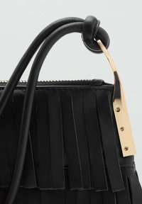 Borsa a tracolla in pelle nera con dettagli in frange, hardware dorato e superficie testurizzata. Presenta due manici e una chiusura con cerniera.