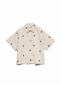 Camisa beige de manga corta con botones y cuello, que presenta pequeños patrones bordados en forma de rombo negro distribuidos de manera uniforme.