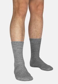 Graue gerippte Socken aus strukturiertem Stoff, die den Unterschenkel bedecken, mit gemustertem Design und engem Sitz am Bund.