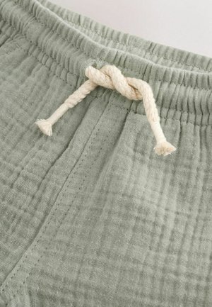 Lysegrønne bomuldsshorts med en struktureret finish. Har elastik i taljen og en cremefarvet snøre med knude.
