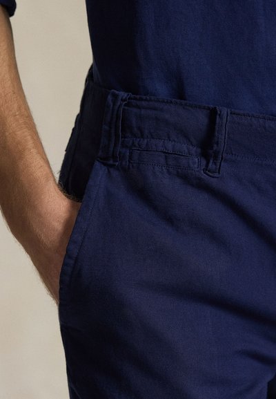 Κοντά σορτς από ύφασμα σε ναυτικό μπλε, με υφή, διαθέτουν πλαϊνή τσέπη και ζώνη μέσης με εμφανείς λεπτομέρειες ραφής.