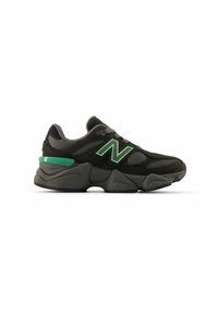 Sneaker sportivo nero con tomaia in mesh e sintetico, dettagli verdi, suola voluminosa e il logo 'N' in evidenza. Presenta un colletto imbottito e una finitura testurizzata.