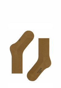 Para brązowych skarpetek z ściągaczami, jedna skarpeta leży płasko, a druga jest pod kątem, z napisem "FALKE FAMILY" na podeszwie.