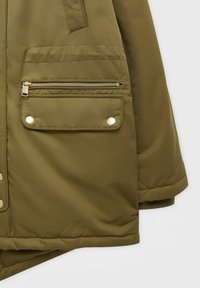 Section de veste matelassée verte montrant une manche et une poche avec une fermeture éclair et un rabat fixé par deux boutons-pression métalliques.