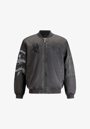 Black bomber jacket in a satin finish. Features embroidered eagle and text details on front and sleeve, zippered pocket, and ribbed cuffs.