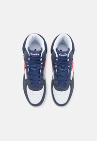 Sneakers con una toma superiore blu navy, un puntale bianco e accenti rossi. Presentano lacci tondi, punte forate e un colletto imbottito per il comfort.