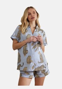 Short-sleeve pajama set featuring blue and white striped fabric adorned with leopard prints; includes a collared shirt and matching shorts.