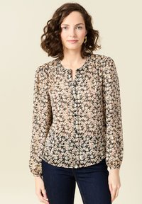 Blusa con stampa floreale, maniche lunghe, scollo rotondo e chiusura con bottoni. Presenta una base nera con fiori rosa e crema e una leggera trasparenza.