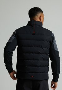 Giacca a vento con colletto alto, in tessuto nero, maniche grigie e dettagli rossi. Presenta un design trapuntato e un logo sull'orlo.