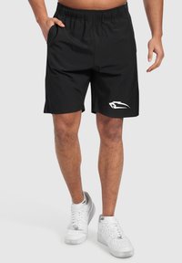 Svarta träningsshorts i lätt tyg med elastisk midja, med sidofickor och en vit logotyp på vänster ben.