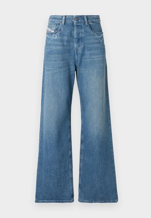 Wide-leg denim jeans in light blue with embellishments on the front pockets. Features a high waist and a smooth texture.