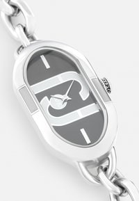 Zilveren horloge met een ovale kast, donkergrijze wijzerplaat met gedurfde zilveren accenten, een gekoppelde metalen band en een opvallende kroon detail.