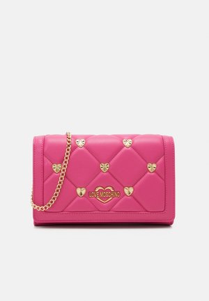 Sac à main matelassé rose avec des clous en forme de cœur dorés, une bandoulière chaîne dorée et un logo Love Moschino doré sur le devant.