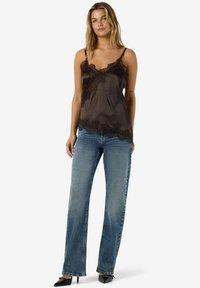 Mustast satiinist kamisol pitsist äärisega, kombineeritud helesiniste sirge säärega teksade ja mustade terava ninaga kontsakingadega. Lihtne disain ja sile tekstuur.