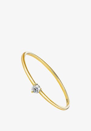 Anillo de oro con una banda delgada y lisa, y una gema redonda y clara engastada en un marco decorativo en el centro.