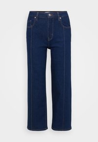 Jeans de perna larga azul-escuro feitos de denim, com fecho de zíper frontal, botão metálico e costura laranja em contraste nas costuras.